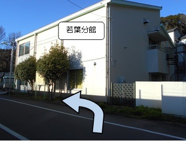 道なりに進むと正面に見える白い建物が若葉分館です。入り口まで進みます。